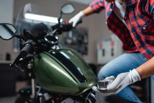 Vue recadrée du technicien tenant manomètre tout en mesurant la pression d'air dans le pneu de la moto, avant-plan flou — Photo de stock