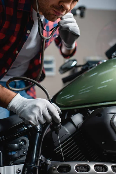 Partial view of mechanic making diagnostics of motorcycle engine with stethoscope — Stock Photo