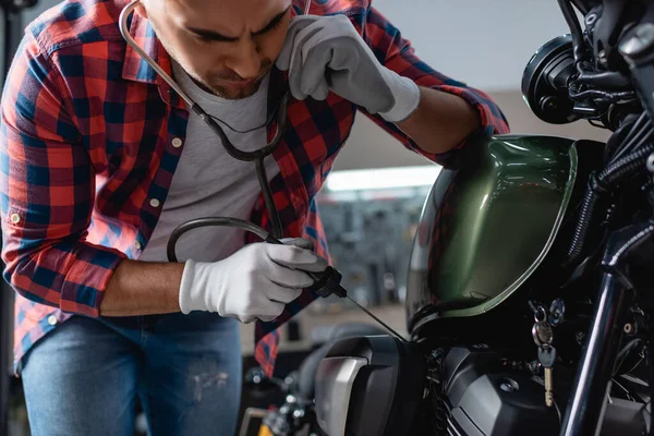 Junger Mechaniker in Handschuhen überprüft Motorradmotor mit Stethoskop — Stockfoto