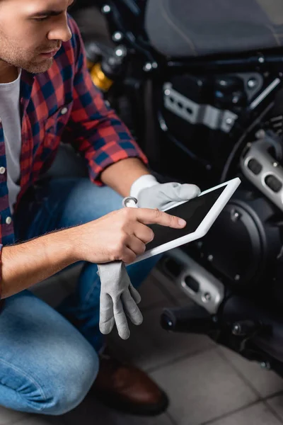 Giovane meccanico che punta con il dito al tablet digitale in officina — Foto stock