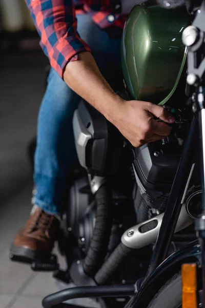Vista ritagliata del meccanico che fa la diagnostica del motociclo nell'officina, sfondo sfocato — Stock Photo