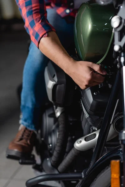 Vista ritagliata del meccanico che fa la diagnostica del motociclo nell'officina, sfondo sfocato — Foto stock