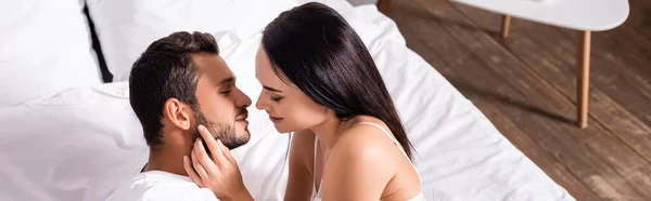 Hochwinkel-Ansicht von sexy Frau verführt jungen Mann im Schlafzimmer, Banner — Stockfoto