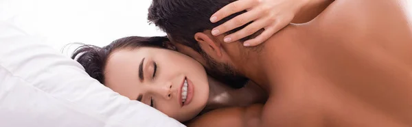 Vista posterior de un hombre joven besar a una mujer sensual con los ojos cerrados en la cama, pancarta - foto de stock