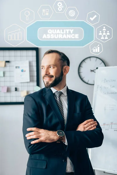 Smiling investor with crossed arms looking away near quality assurance illustration — Stock Photo