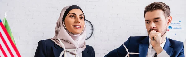 Счастливая арабская предпринимательница рядом с моделями ветрогенератора и переводчика, баннер — стоковое фото