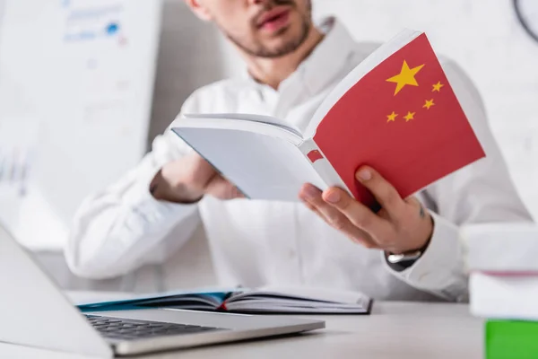 Selective focus of chinese dictionary in hand of translator, cropped view — Stock Photo