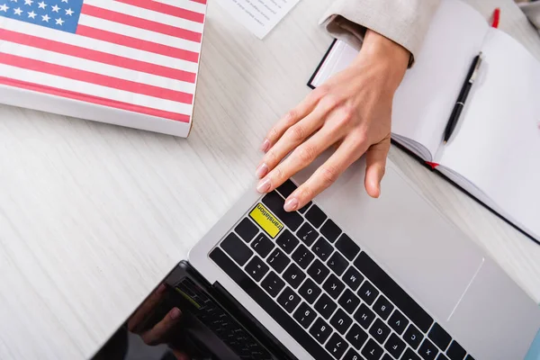 Cropped view of interpreter pressing translation key on keyboard near american english dictionary — Stock Photo