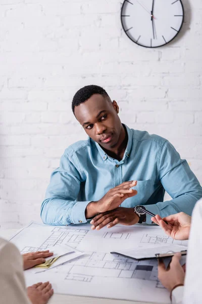 Afrikanischer amerikanischer Geschäftsmann zeigt Verweigerungsgeste gegenüber Geschäftspartnern, die ihm Bestechungsgeld und Vertrag zur Unterzeichnung geben — Stockfoto