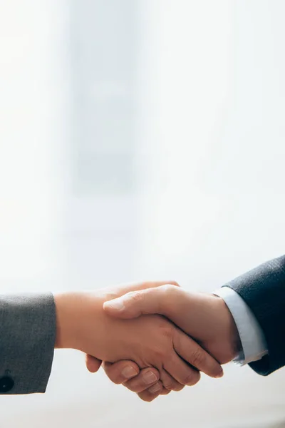 Cropped view of business partners shaking hands in office — Stock Photo