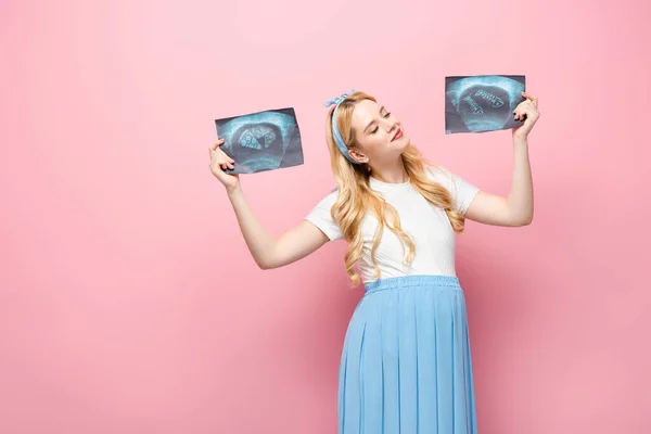 Happy blonde young pregnant woman with ultrasound scan with pizza and fish on pink background — Stock Photo