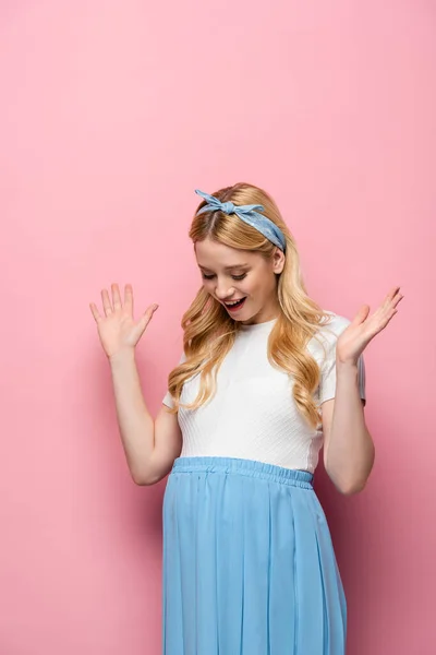 Überrascht blonde junge schwangere Frau auf rosa Hintergrund — Stockfoto