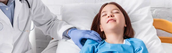 Pediatrician examining sick girl lying in bed with closed eyes, banner — Fotografia de Stock