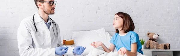 Arzt und Mädchen im Bett gestikulieren, während sie im Krankenhaus sprechen, Transparent — Stockfoto