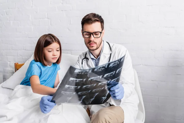 Педіатр і дитина, дивлячись на рентген в лікарні — стокове фото