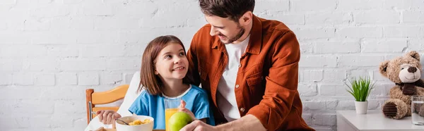 Happy girl looking at father during breakfast in hospital, banner - foto de stock