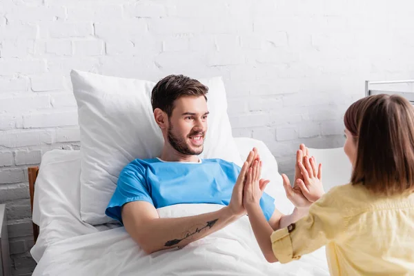 Happy father playing patty-cake game with daughter in hospital — Stock Photo