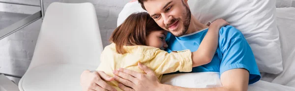 Tochter umarmt glücklichen Vater im Krankenhausbett liegend, Transparent — Stockfoto