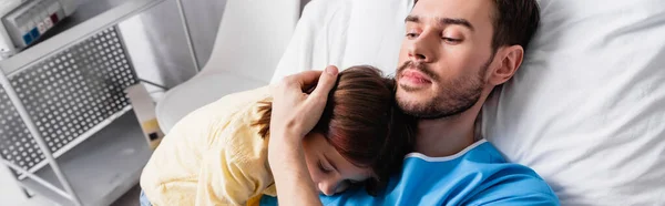 Père malade embrassant sa fille alors qu'il était allongé à l'hôpital, bannière — Photo de stock