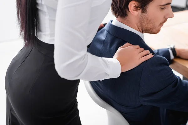 Sexy secretary touching shoulder of businessman in office — Stock Photo