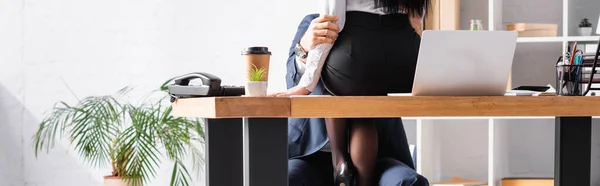 Teilansicht der Sekretärin, die auf dem Schreibtisch sitzt, während sie Geschäftsmann im Büro verführt, Banner — Stockfoto
