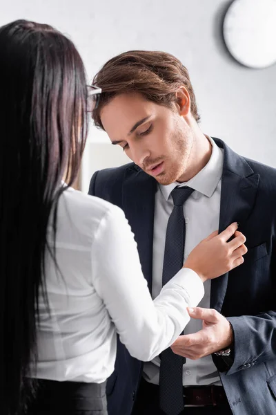 Back view of brunette businesswoman seducing young colleague in office — Stock Photo