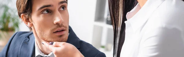 Businesswoman touching chin of young colleague while seducing him in office, banner — Stock Photo