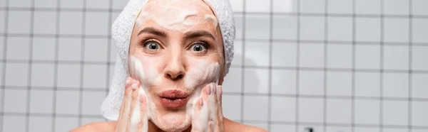 Mujer sorprendida aplicando limpiador de espuma en el baño, pancarta - foto de stock