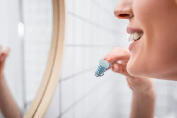 Vista recortada de mujer alegre sosteniendo cepillo de dientes con pasta de dientes - foto de stock