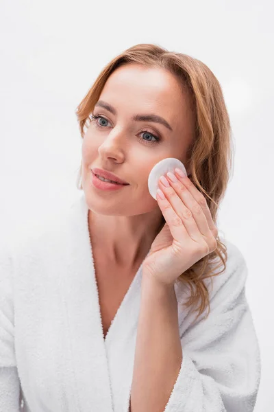 Pleased woman applying toner with cotton pad on face — Stock Photo