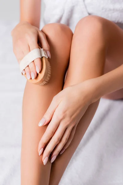 Cropped view of young woman exfoliating skin on leg — Stock Photo