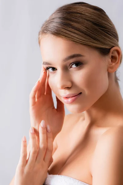 Sensuelle jeune femme regardant caméra et toucher le visage sur blanc — Photo de stock