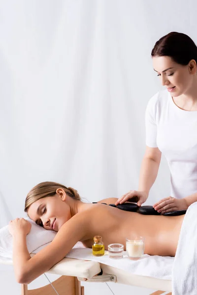 Jeune femme se faire masser la pierre chaude dans le salon de spa — Photo de stock