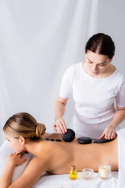 Masseur tut Hot-Stone-Massage für Kunden im Wellness-Salon — Stockfoto