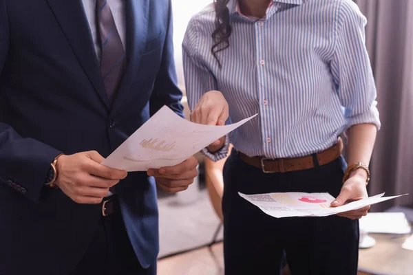 Partial view of business partners analyzing infographics in restaurant — Stock Photo
