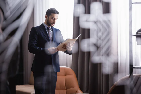 Muslim businessman holding paper folder in restaurant — Stock Photo