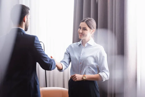 Smiling businessman handshaking with arabian partner in restaurant — Stock Photo