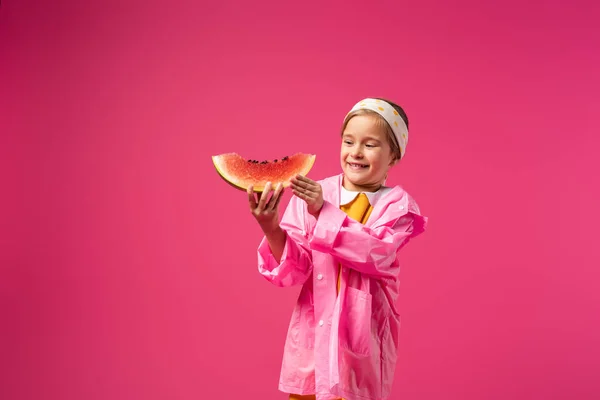 Glückliches Mädchen im Regenmantel mit Wassermelone in Purpur — Stockfoto