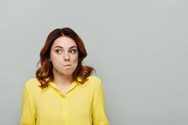 Femme découragée avec les cheveux bouclés regardant loin isolé sur gris — Photo de stock