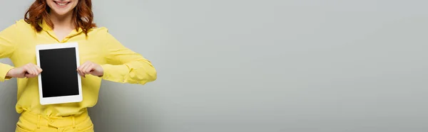 Cropped view of smiling woman holding digital tablet with blank screen on grey, banner — Stock Photo