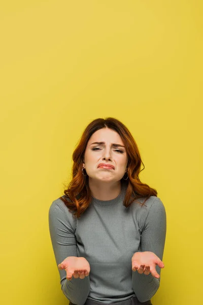 Offended woman grimacing while looking at camera on yellow — Stock Photo