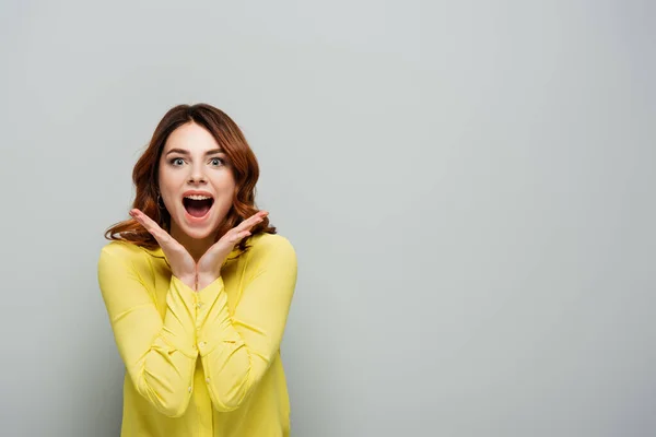 Eccitato giovane donna con la bocca aperta gesticolando isolato su grigio — Foto stock