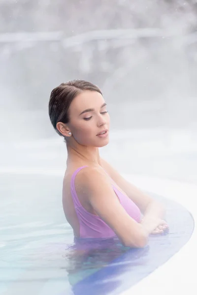 Dampf in der Nähe einer jungen Frau beim Baden im Thermalfreibad — Stockfoto