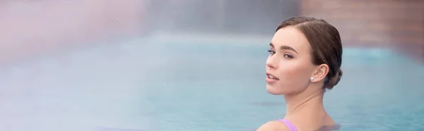 Jeune femme regardant loin et prenant bain dans la piscine extérieure de source chaude, bannière — Photo de stock