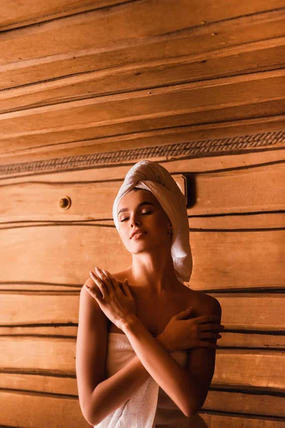 Zufriedene Frau in Handtücher gehüllt entspannt sich in Sauna — Stockfoto