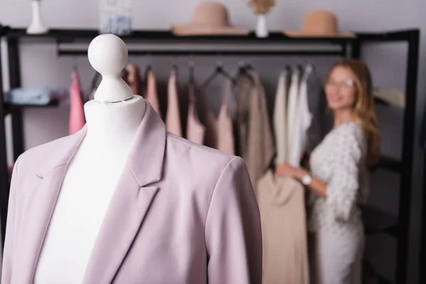 Foyer sélectif du blazer sur mannequin près du propriétaire du showroom sur fond flou — Photo de stock