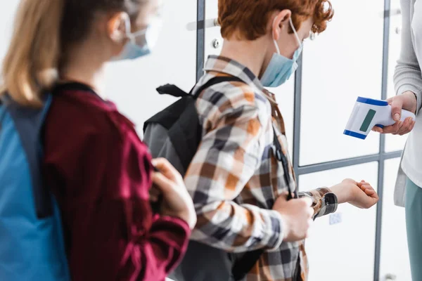 Lehrer überprüft Temperatur des Schülers während Quarantäne mit Infrarot-Thermometer — Stockfoto