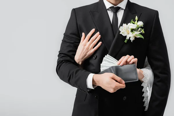 Vista cortada de noiva abraçando noivo com dinheiro em carteira isolada em cinza — Fotografia de Stock