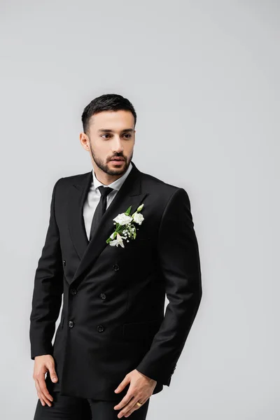 Muslim groom in suit and floral boutonniere isolated on grey — Stock Photo
