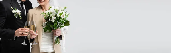 Vista recortada de la novia sonriente brindis champán con novio aislado en gris, pancarta - foto de stock